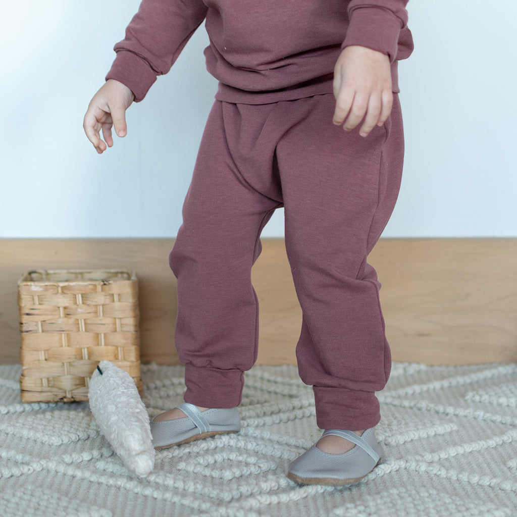 A toddler standing up, wearing harem pants in Berry.